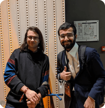 Rasikh Morani giving a thumbs up with a colleague