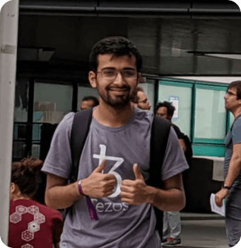 Rasikh Morani in a Tezos shirt giving a double thumbs up
